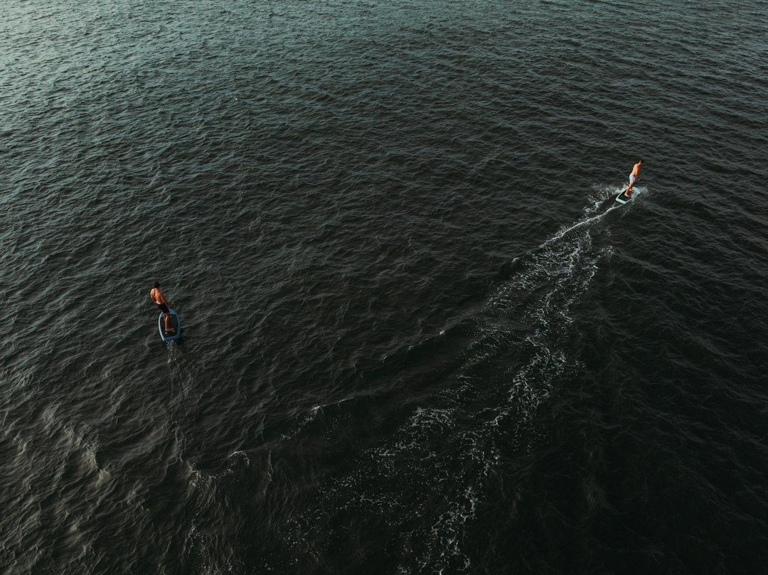 Deux nageurs sur des planches avancent dans une mer agitée