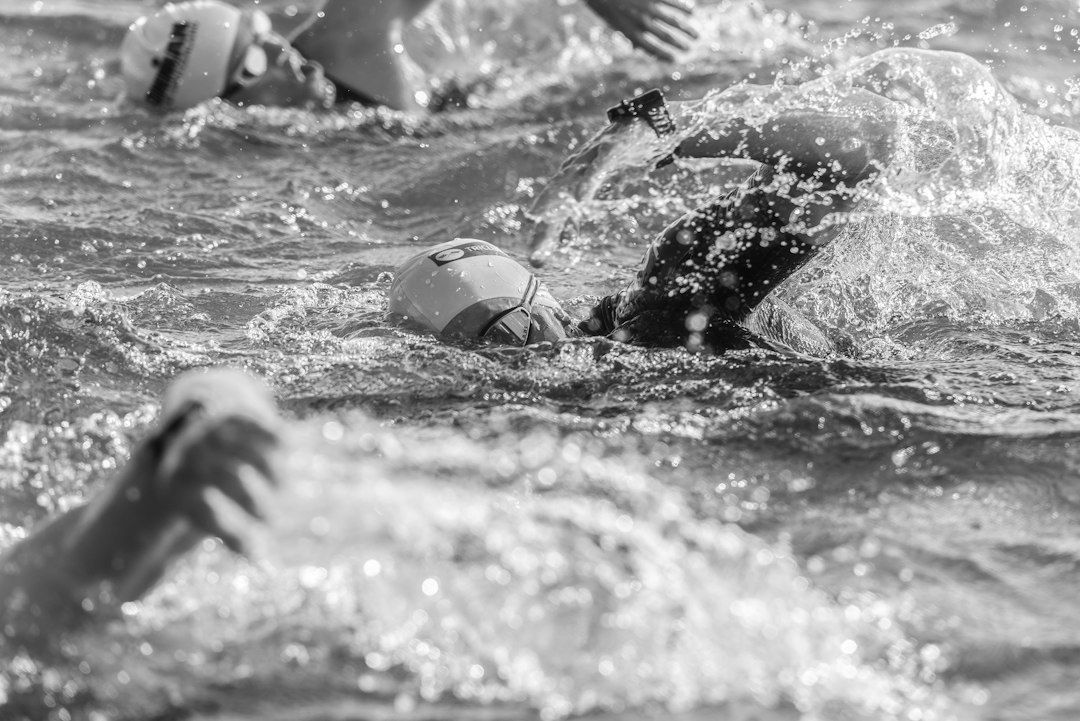 Nageurs de triathlon groupés dans une eau agitée, en plein effort